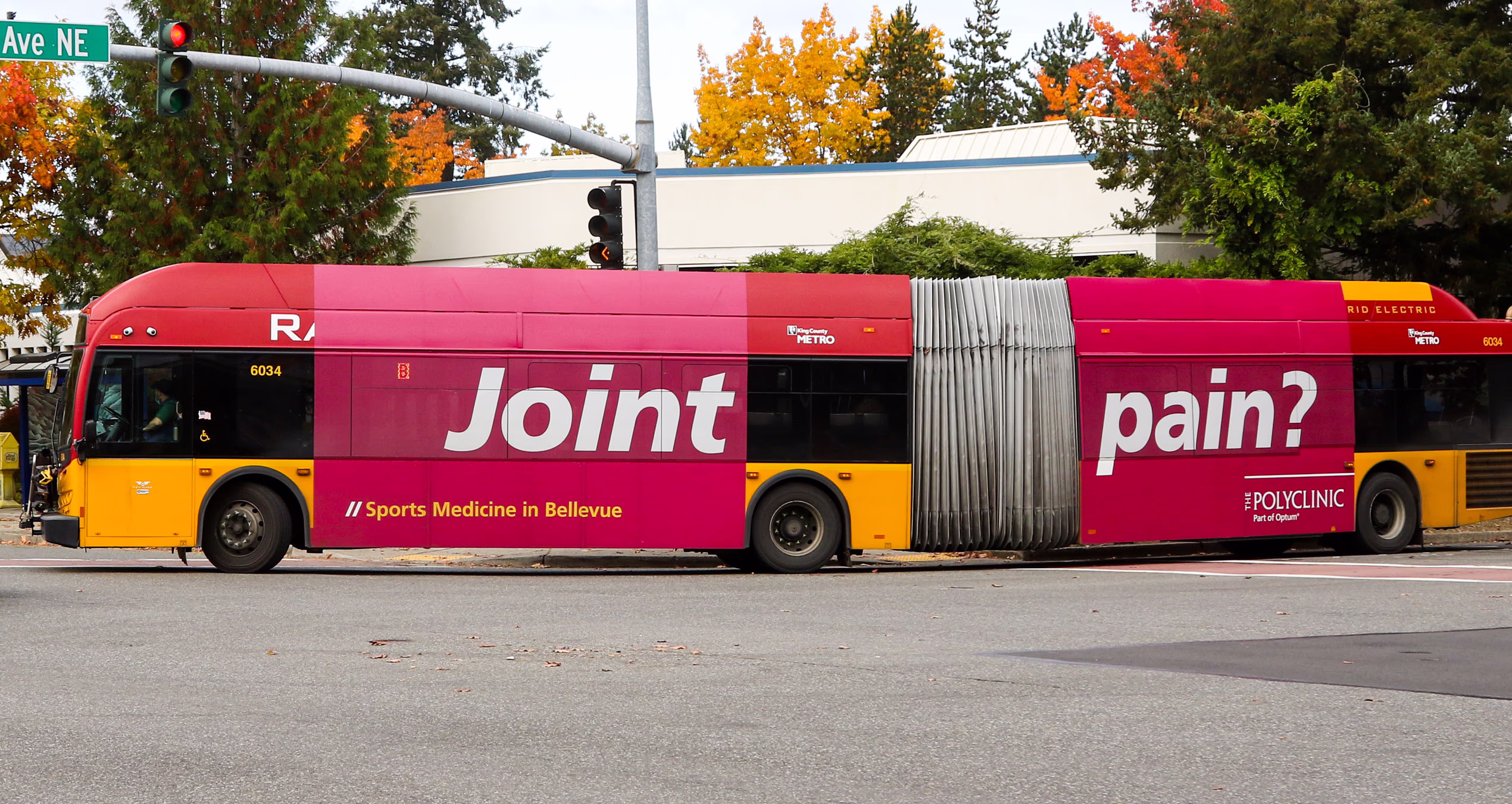 City bus featuring an ad for The Polyclinic. Bold text headline: Joint Pain