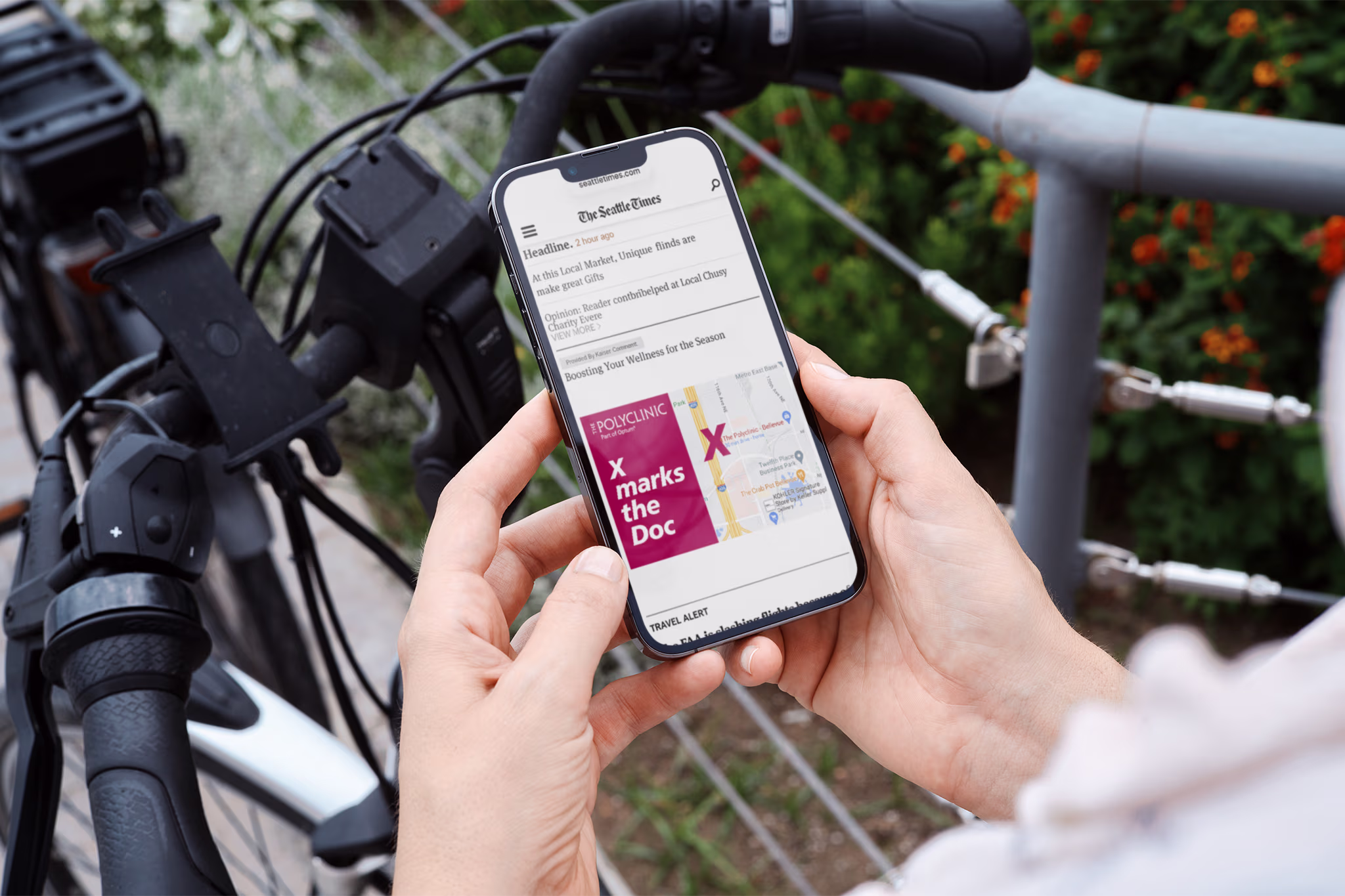 Person viewing The Polyclinic ad reading ‘X marks the Doc’ on a smartphone beside a bicycle.